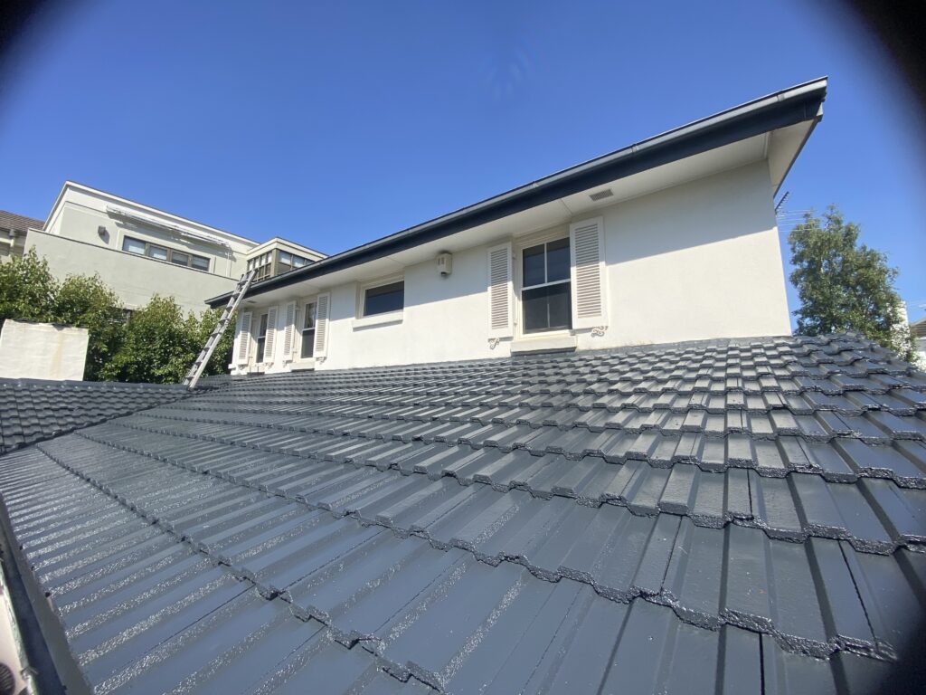 Completed concrete tile roof restoration with a uniform charcoal finish