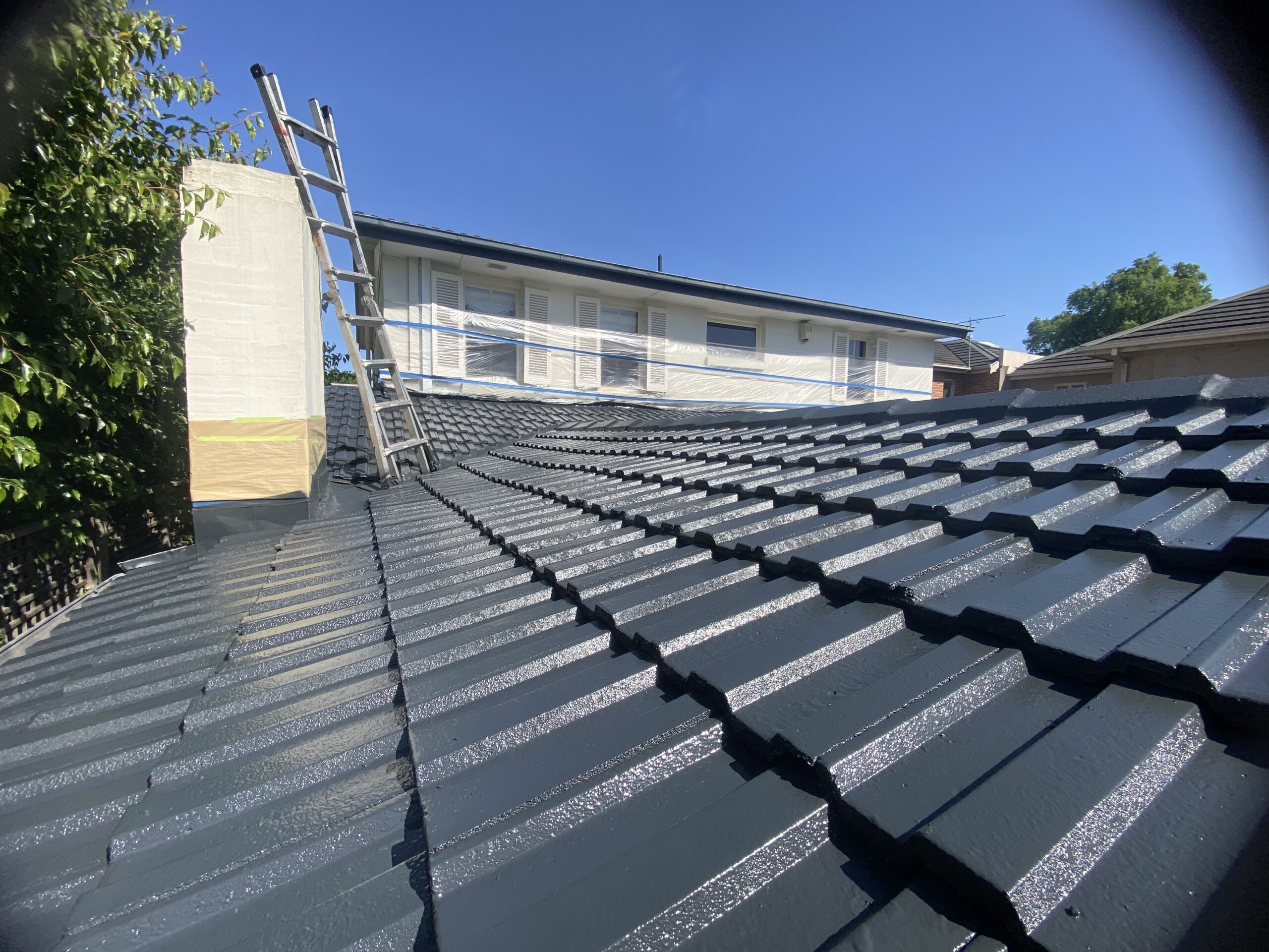 Close-up of concrete roof tiles coated with charcoal Dulux roof membrane