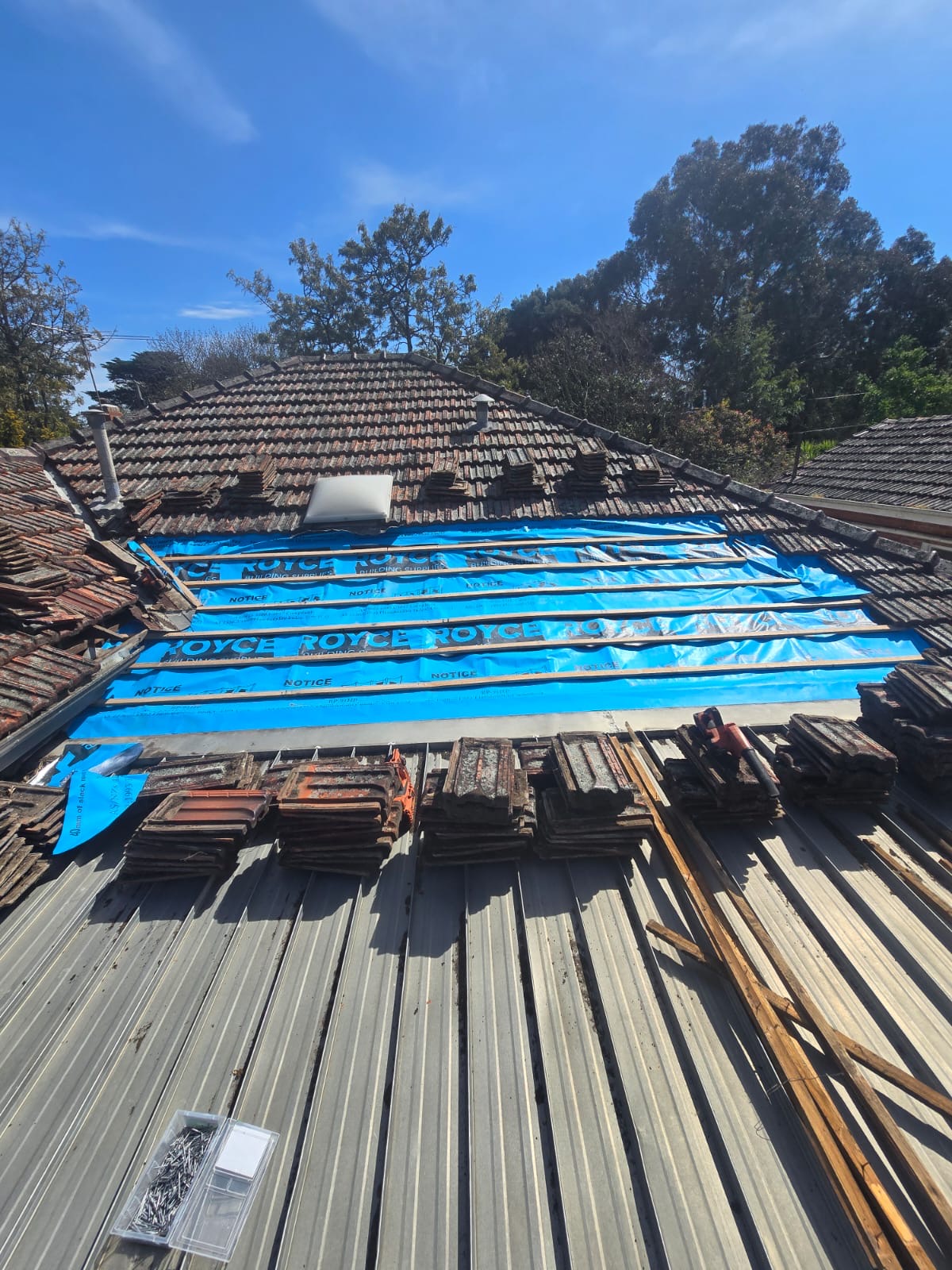 Blue roof sarking and new timber tile battens installed across the exposed skillion roof section