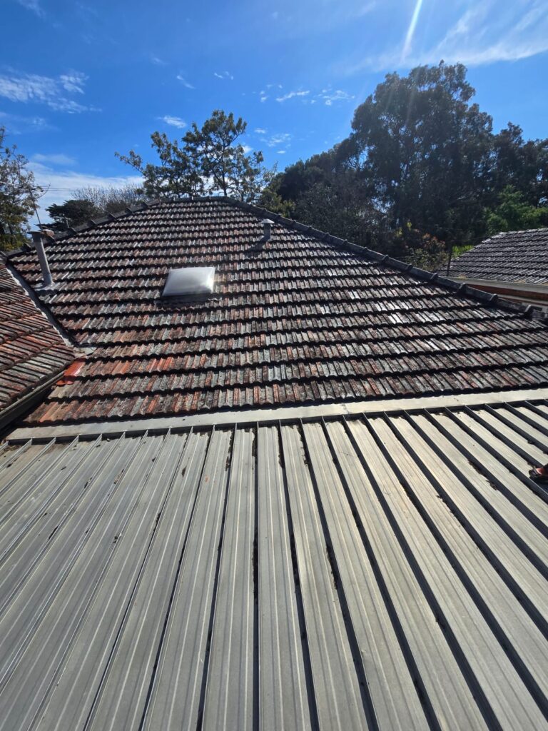 Terracotta roof tiles reinstated over the repaired skillion section after sarking and batten installation