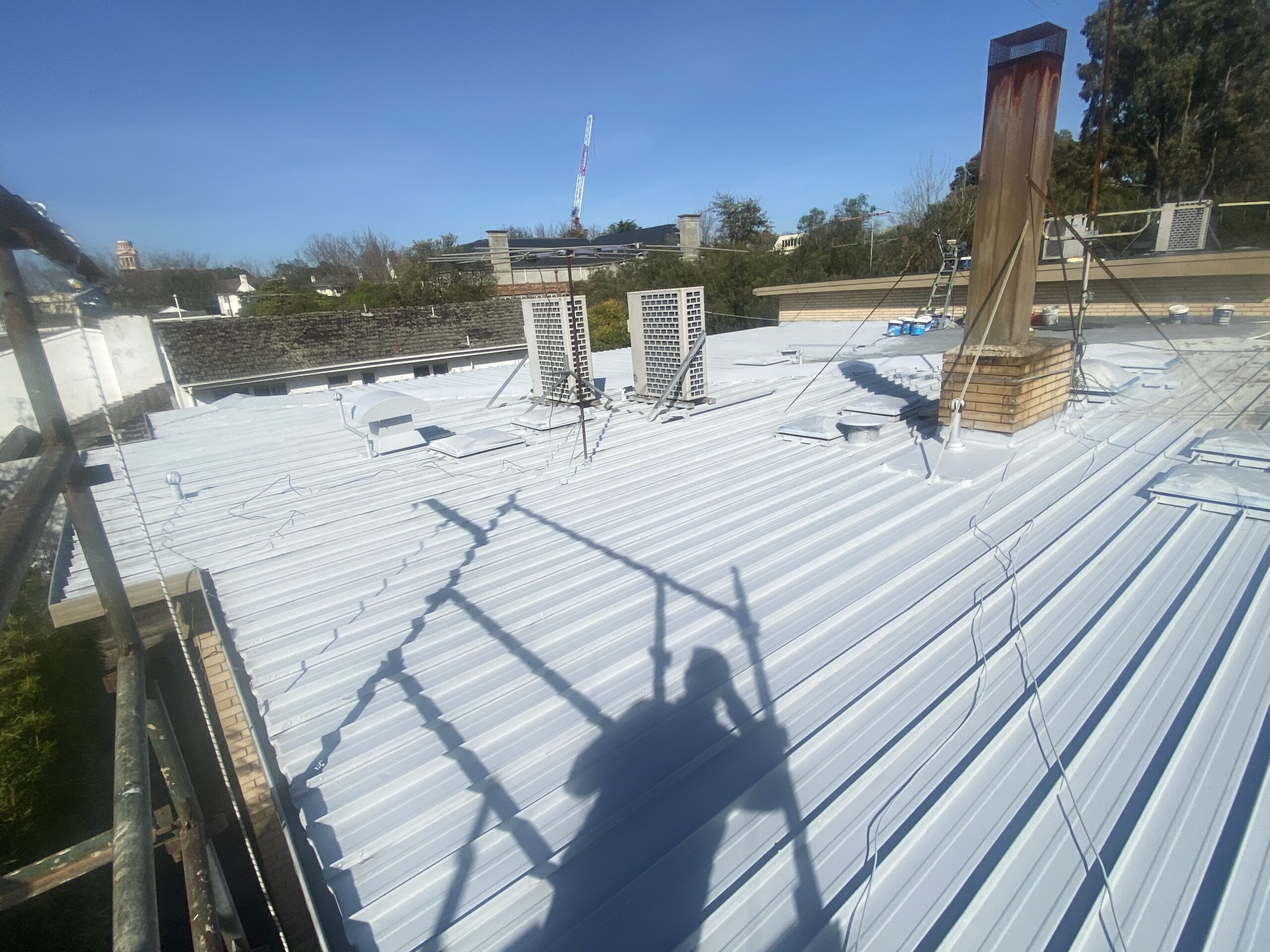 Light-coloured coating around rooftop air-conditioning units and a chimney